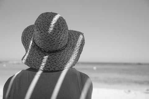 mujer usando sombrero para cuidar el cabello en verano